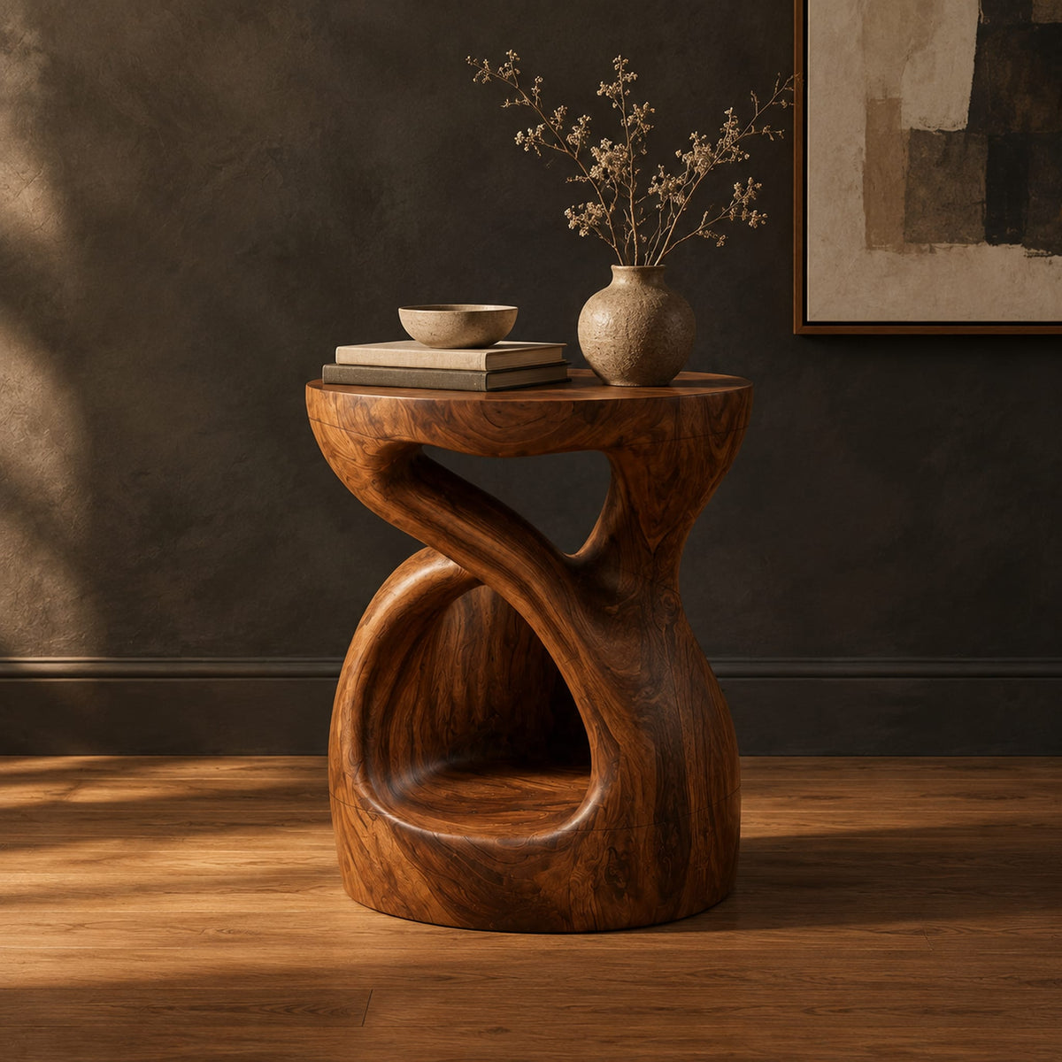 Chunky side table with a looping open body and thick flat top in a dark studio against a charcoal plaster wall