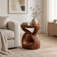 Chunky side table with a looping open body and thick flat top in a Scandinavian living room with white walls