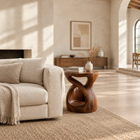 Chunky side table with a looping open body and thick flat top in a bright open plan living room
