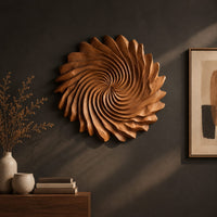 Detail of circular wall art with spiral petal carving and a ruffled edge beside wood, brass and linen samples