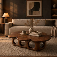 Cloud shaped coffee table on a base of round arches in a dark living room at golden hour
