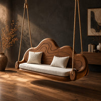 Cloud shaped swing with a carved wavy backrest and cream seat cushion, three-quarter view showing the grain