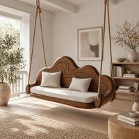 Cloud shaped swing with a carved wavy backrest and cream seat cushion in a Scandinavian porch with white walls