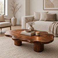Low coffee table with a cloud shaped wavy top on thick cylinder legs in a Scandinavian living room with white walls