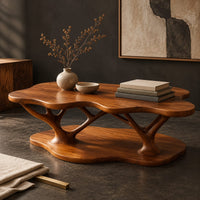 Corner detail of coffee table with a cloud shaped top and branching legs beside wood, brass and linen samples