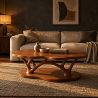 Cloud shaped coffee table with forked branch legs over a matching shaped base in a dark living room at golden hour