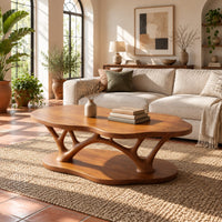 Cloud shaped coffee table with forked branch legs over a matching shaped base in a bright living room with arched windows and plants