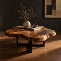 Cloud shaped coffee table with a thick slab top on a slim cross base, three-quarter view showing the grain
