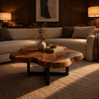 Cloud shaped coffee table with a thick slab top on a slim cross base in an evening living room with walnut wall paneling