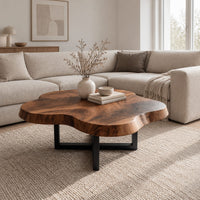 Cloud shaped coffee table with a thick slab top on a slim cross base in a Scandinavian living room with white walls