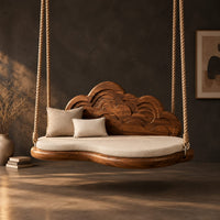 Cloud shaped swing with a carved wave backrest and a cushioned seat in a dark studio against a charcoal plaster wall