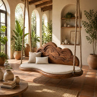 Cloud shaped swing with a carved wave backrest and a cushioned seat in a bright porch with arched windows and plants