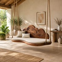 Cloud shaped swing with a carved wave backrest and a cushioned seat in a bright open plan porch