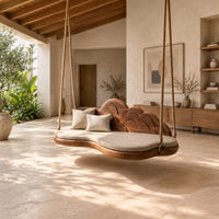 Cloud shaped swing with a scalloped carved back and a padded seat in a bright open plan porch