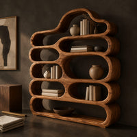 Corner detail of wide wooden bookshelf with stacked pill shaped shelves and a cloud shaped top beside wood, brass and linen samples