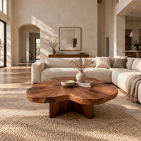 Clover shaped coffee table with a thick top and cross shaped pedestal in a bright open plan living room