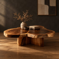 Clover shaped coffee table with three joined slabs on a three fin base in a dark studio against a charcoal plaster wall