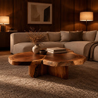 Clover shaped coffee table with three joined slabs on a three fin base in an evening living room with walnut wall paneling
