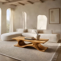 Minimal coffee table with an S curve waist base in a bright modern living room