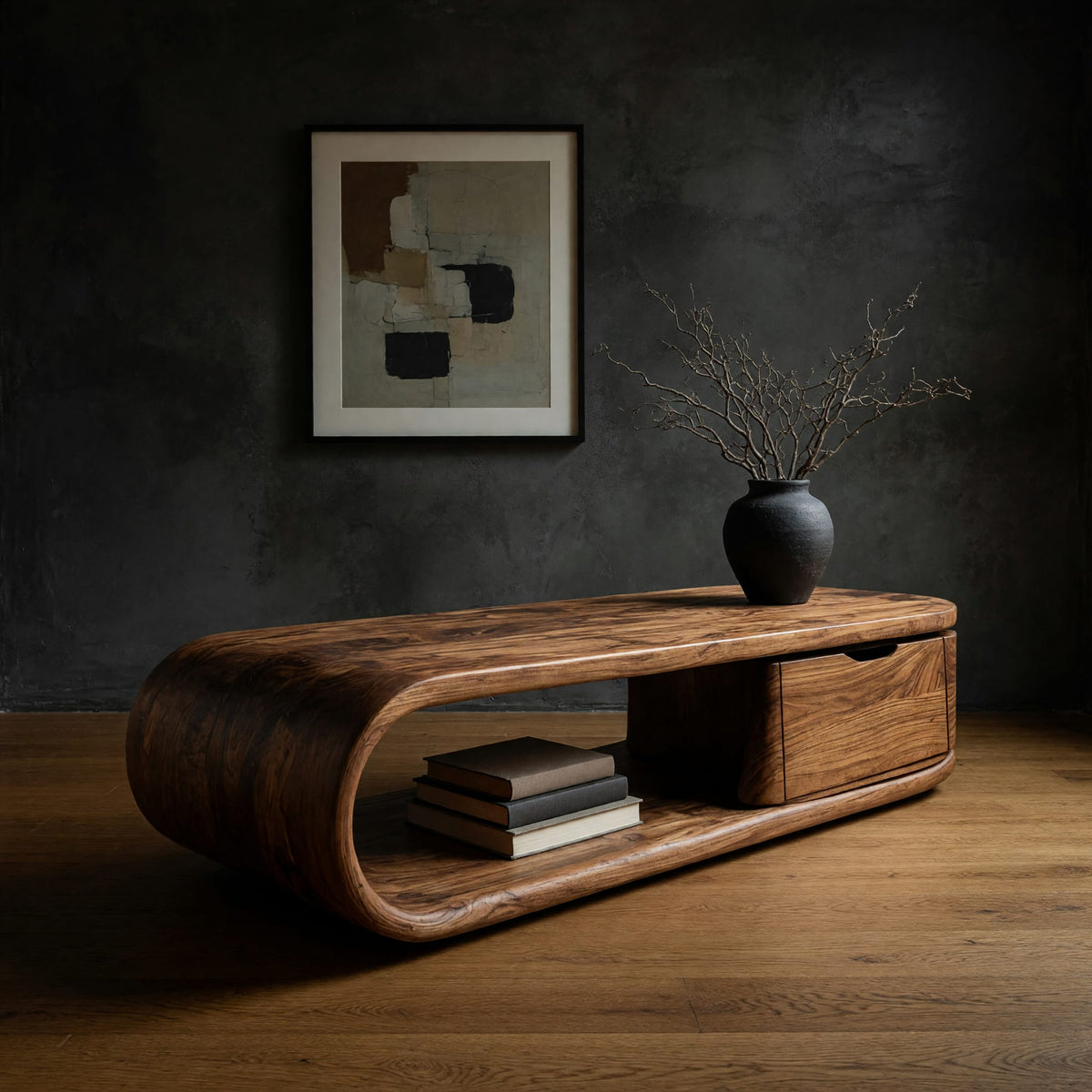 Long loop coffee table with a side drawer box in a dark studio against a charcoal wall