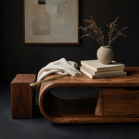 Corner detail of long loop coffee table with a side drawer box beside wood, brass and linen samples