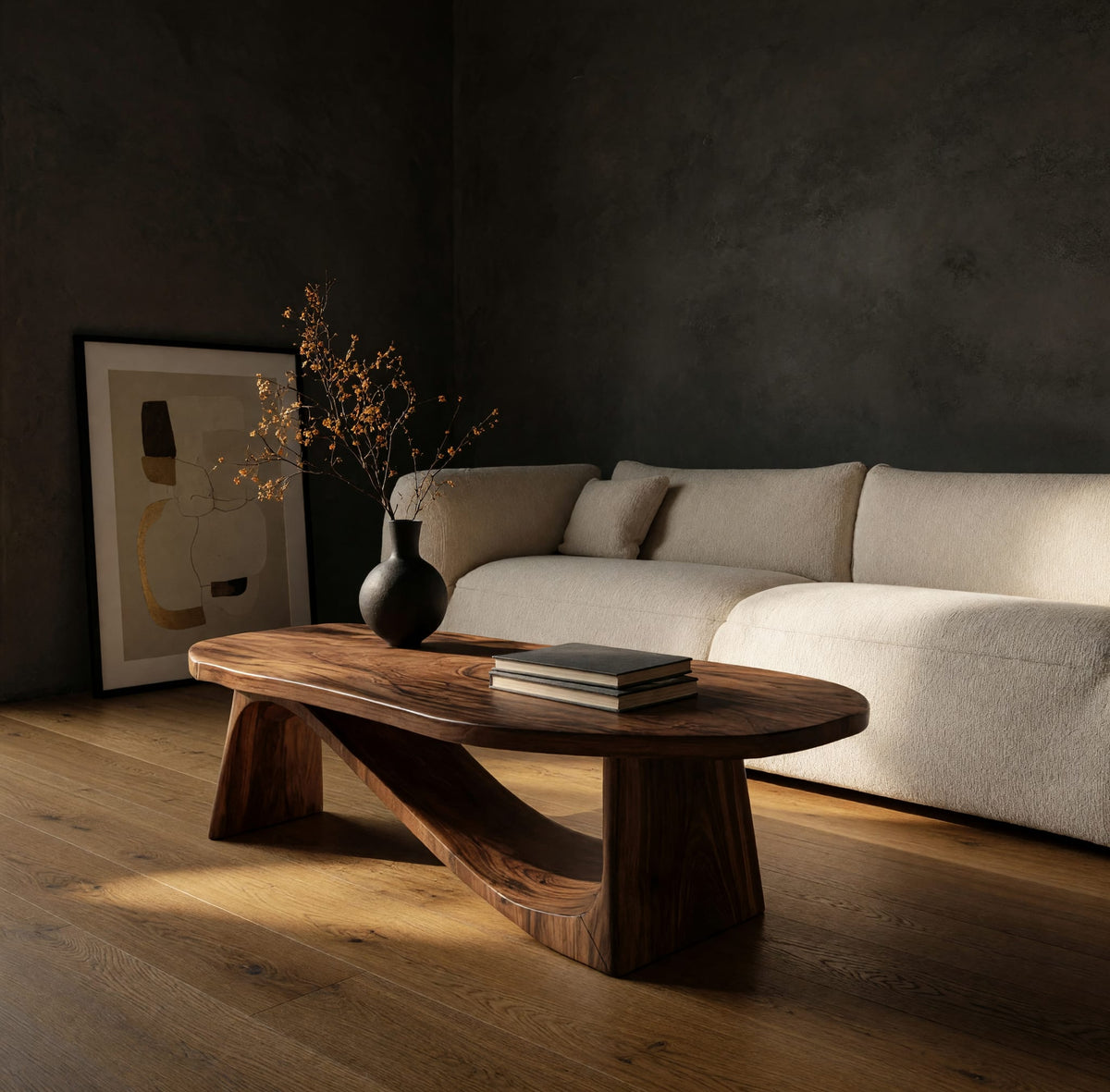 Coffee table on angled plank legs with a swooping brace in a dark studio against a charcoal wall