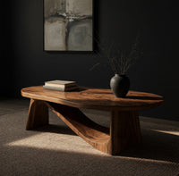 Coffee table on angled plank legs with a swooping brace, three-quarter view showing the grain
