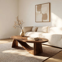 Coffee table on angled plank legs with a swooping brace in a bright modern living room