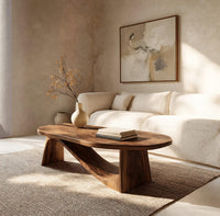 Coffee table on angled plank legs with a swooping brace in an open plan space in daylight