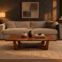 Rectangular coffee table on an arched trestle base with a low curved beam in a dark living room at golden hour
