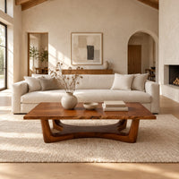 Rectangular coffee table on an arched trestle base with a low curved beam in a bright open plan living room