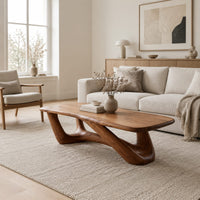 Coffee table with an irregular soft edged top on sculpted branching legs in a Scandinavian living room with white walls