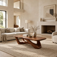 Coffee table with an irregular soft edged top on sculpted branching legs in a bright open plan living room