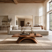 Coffee table with a natural edge top on a fanned arch base in a bright open plan living room