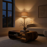 Coffee table with rolled ends and a double open shelf in an evening room lit by two lamps