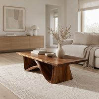 Coffee table with a tapered block pedestal and a swooping wood loop in a Scandinavian living room with white walls