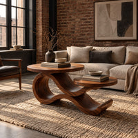 Wooden coffee table with two circular tops on a swooping ribbon base in an industrial loft living room with exposed brick