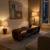 Compact loop coffee table with a small drawer in an evening room lit by two lamps
