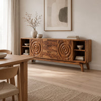 Sideboard with ring carved panels and open end shelves on angled legs in a Scandinavian dining room with white walls