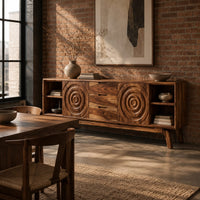 Sideboard with ring carved panels and open end shelves on angled legs in an industrial loft dining room with exposed brick