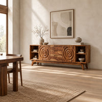 Sideboard with ring carved panels and open end shelves on angled legs in a bright open plan dining room