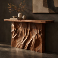 Corner detail of console table with a deeply ridged sculpted block base beside wood, brass and linen samples