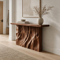Console table with a deeply ridged sculpted block base in a Scandinavian entryway with white walls