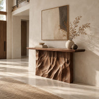 Console table with a deeply ridged sculpted block base in a bright open plan entryway