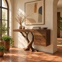 Console table on a branching trunk base with a four drawer block in a bright entryway with arched windows and plants