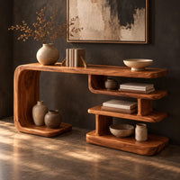 Long console table with a bent side panel and stacked open shelves, three-quarter view showing the grain
