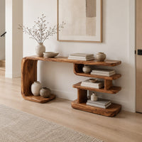Long console table with a bent side panel and stacked open shelves in a Scandinavian entryway with white walls
