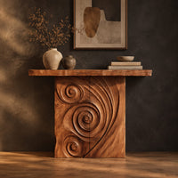 Console table with a spiral carved front and a slab top in a dark studio against a charcoal plaster wall