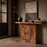 Console table with a spiral carved front and a slab top in an industrial loft entryway with exposed brick