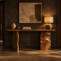 Console table with a slab top and one leg carved in flowing waves in a dark entryway at golden hour